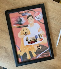 a framed picture of a man holding a dog